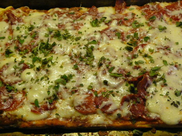 Ein Lebensmittel mit geschmolzenem Käse darauf auf einem Tablett.