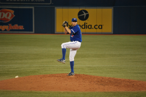 Ein Spieler steht auf dem Boden und hält einen Ball, mit einem großen Banner im Hintergrund.