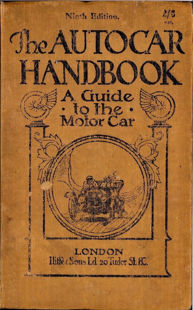 Ein abgenutztes, hellblaues Buch mit der Aufschrift "The Autocar Handbook: A Guide to the Motor Car" liegt auf einer weißen Oberfläche, mit alter und verblasster Schrift auf dem Cover.