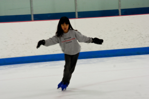 Eine Person in Kleidung fährt auf dem Eis mit Polen an der Spitze des Bildes Schlittschuh