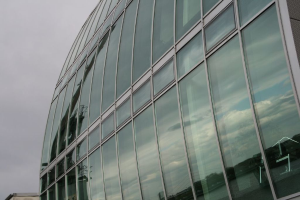 Ein großes Glas-Gebäude unter einem blauen Himmel.