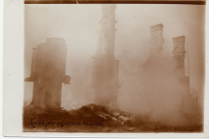 Ein Schwarz-Weiß-Foto eines verfallenen Gebäudes mit bröckelnden Wänden und zerbrochenen Fenstern, umgeben von einem Foto-Rahmen mit Text.