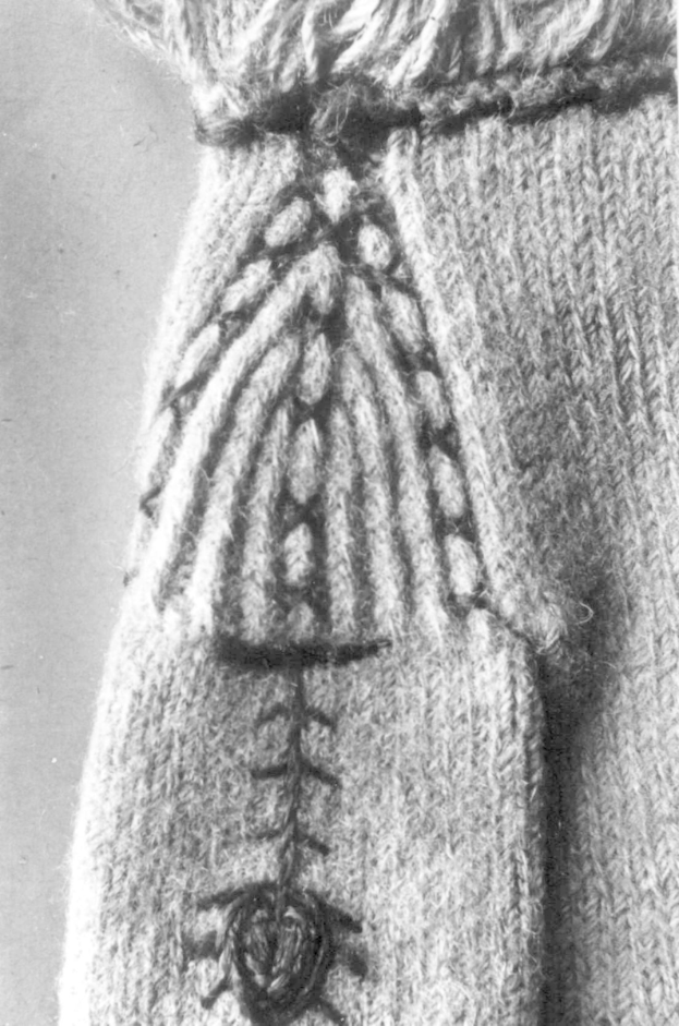 Ein Schwarz-Weiß-Foto eines wollenen Pullovers mit einem detaillierten Muster in verschiedenen Formen und Farben.