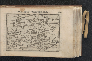 Ein aufgeschlagenes Buch mit einer detaillierten Karte von Westfalen, das auf einer schwarzen Oberfläche liegt.