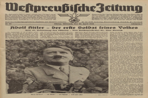 Adolf Hitler, gekleidet in einen schwarzen Anzug und ein weißes Hemd, steht vor einer Menge auf der Titelseite einer deutschen Zeitung mit der Überschrift "Adolf Hitler - Der Erte Soldat Feines Volkes".