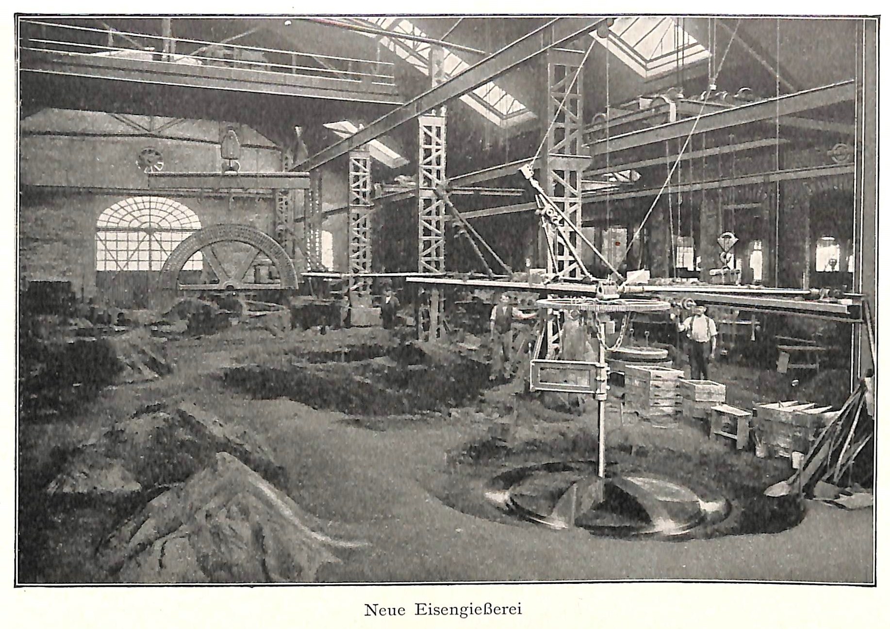Schwarz-weiß-Fotografie eines Fabrikinneren mit Arbeitern an Maschinen, Metallstangen und -rohren, beschriftet mit "Neue Eisenglebeerei, die erste Fabrik in Deutschland" unten.