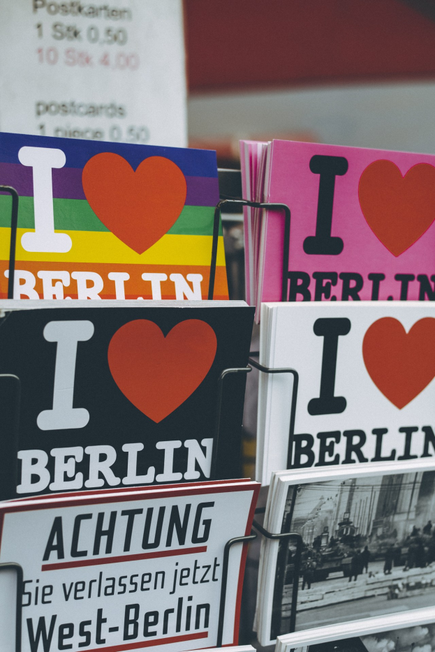 Ein Gestell mit verschiedenen Büchern und Postern mit der Aufschrift "Ich liebe Berlin" vor einem unscharfen, träumerischen Hintergrund.