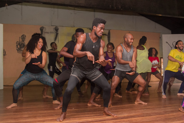 Eine Gruppe von Menschen tanzt in einem Choreografie-Kurs an der Universität Chicago, mit Gemälden an den Wänden im Hintergrund.