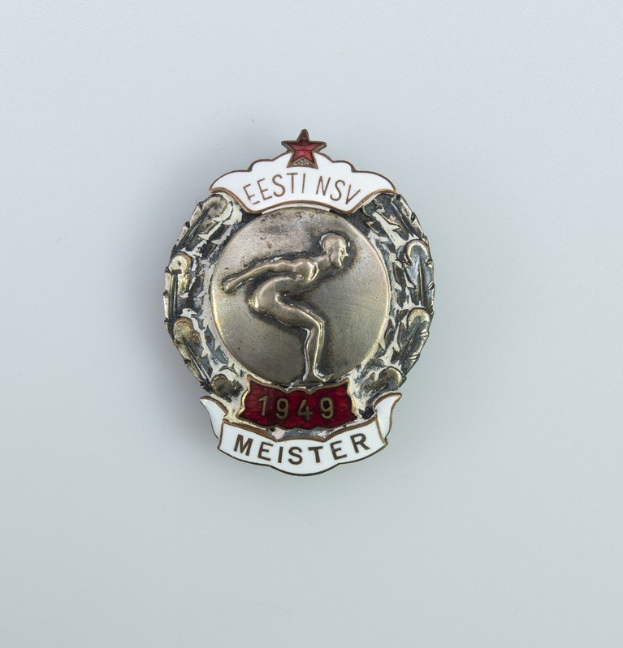 Eine silberne Abzeichen mit einem roten Stern und Text, Emblem der deutschen Olympischen Spiele 1949.