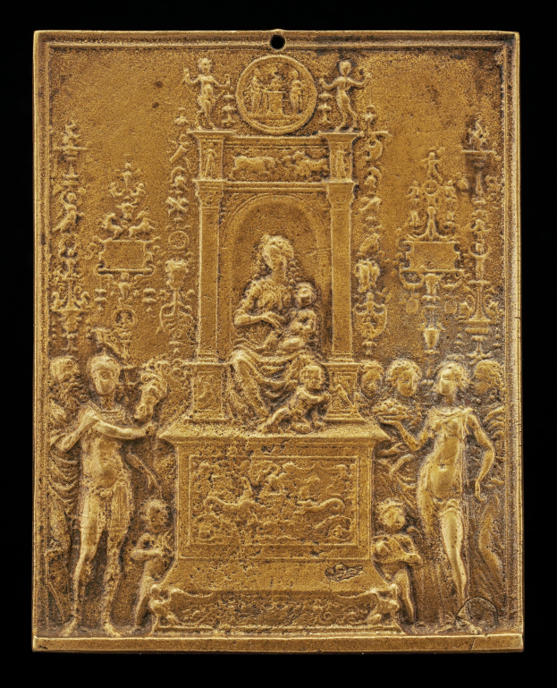 Goldene Plakette mit detaillierter Skulptur einer Frau in einem langen Kleid und eines Mannes in einem Anzug und Krawatte auf schwarzem Hintergrund, umrahmt von einem goldenen Rahmen.