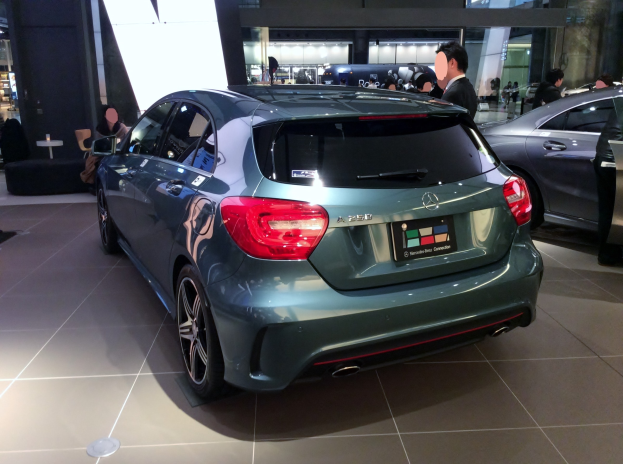 Ein Mercedes-Benz A-Klasse Hatchback mit glänzender schwarzer Lackierung und Chromakzenten wird auf der IAA in Frankfurt von einer Gruppe von Menschen umgeben gezeigt.