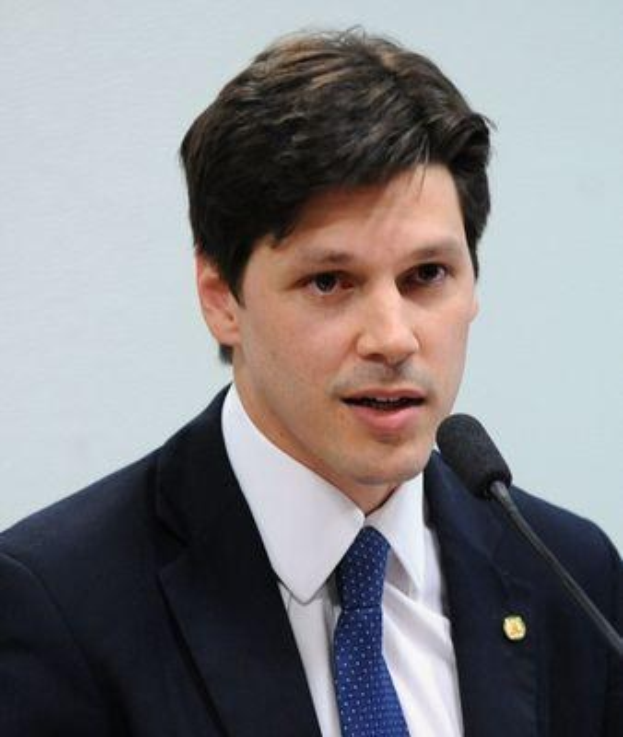 Ein Mann im Anzug spricht in ein Mikrofon an einem Rednerpult, wahrscheinlich über die Genehmigung eines Gesetzes durch die Regierung.